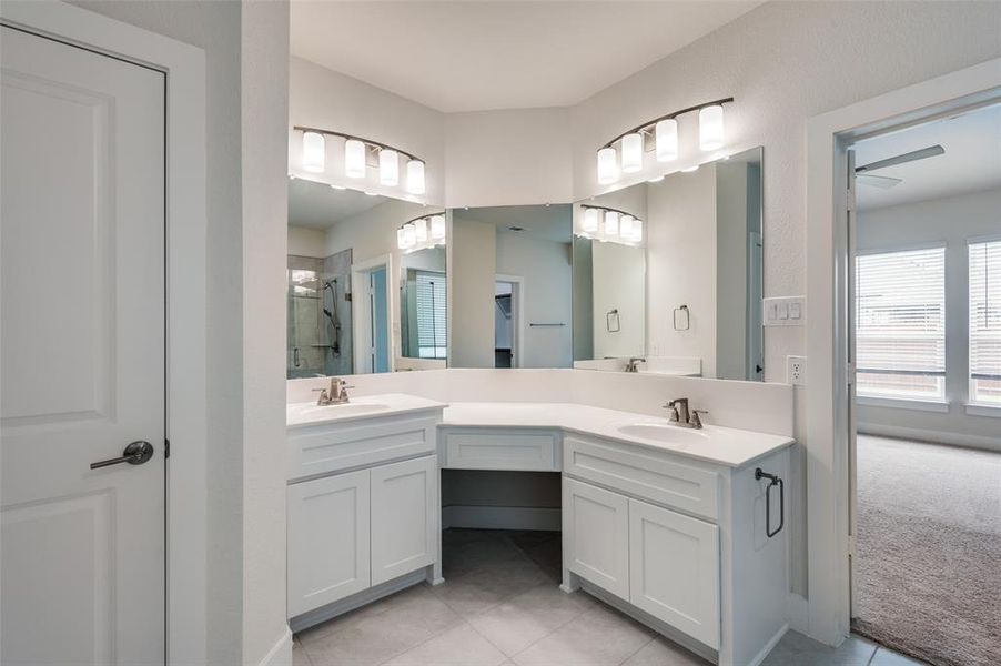 Full bath with tile patterned flooring, a stall shower, double vanity, and ceiling fan Full bath with tile patterned flooring, a stall shower, double vanity, and ceiling fan