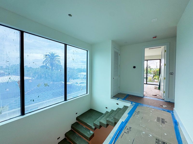 (as of April 8, 2026) the second level is seamlessly connected by the floating concrete staircase, with light pouring in from the full-height picture windows