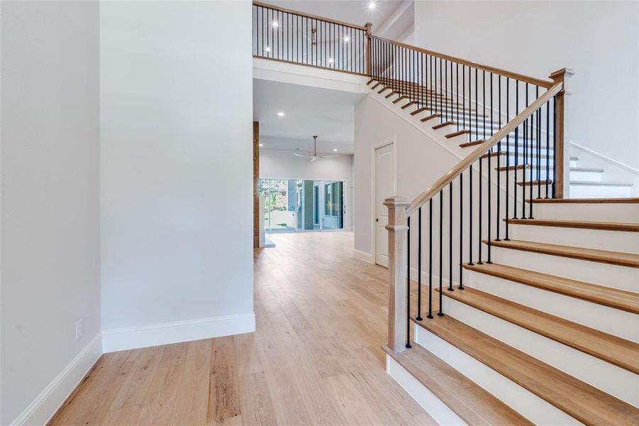Stairs with wood finished floors, a towering ceiling, recessed lighting, and ceiling fan Stairs with wood finished floors, a towering ceiling, recessed lighting, and ceiling fan