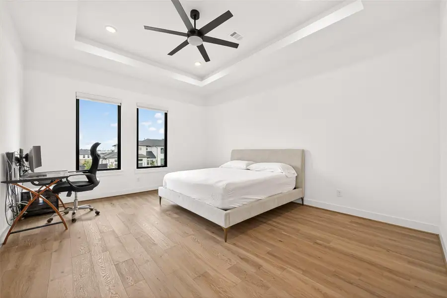 Primary 2: The upstairs second primary suite offers the ultimate private retreat, complete with tray ceilings accented by LED lighting and a luxurious spa bath accessed through double doors.