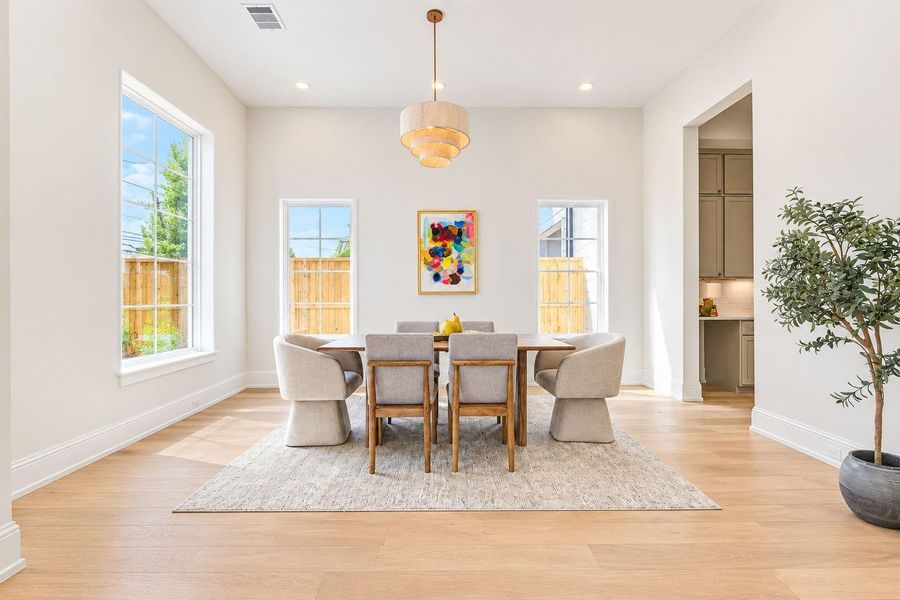 Elegant dining area showcasing beautiful French Oak floors, soaring ceilings, designer lighting, and an abundance of natural light. The open, airy design flows effortlessly into the surrounding living spaces, creating a sophisticated setting for both casual meals and memorable gatherings. Elegant dining area showcasing beautiful French Oak floors, soaring ceilings, designer lighting, and an abundance of natural light. The open, airy design flows effortlessly into the surrounding living spaces, creating a sophisticated setting for both casual meals and memorable gatherings.
