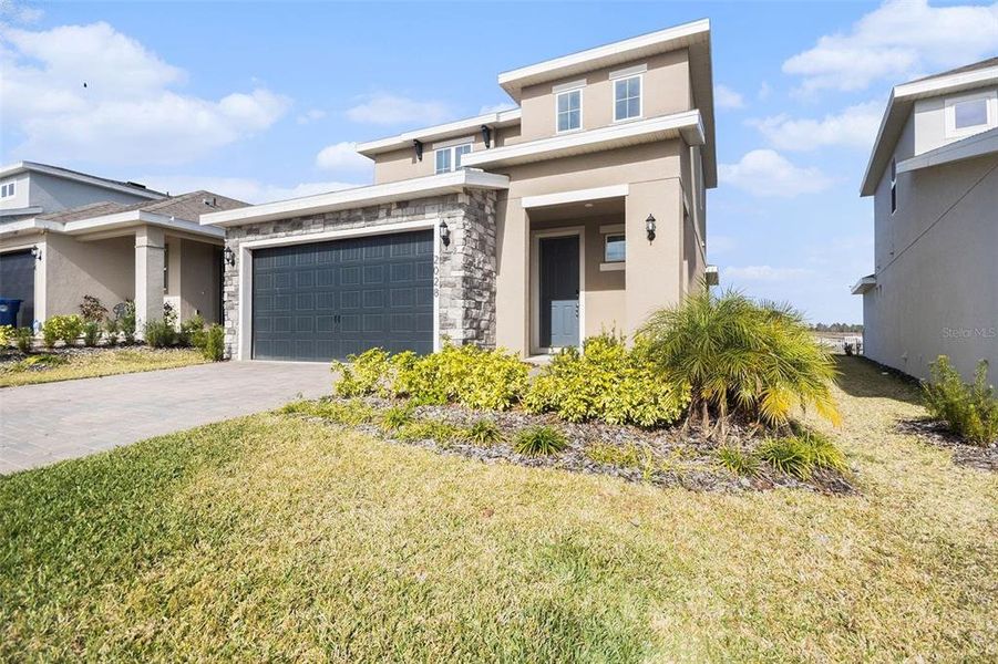 Front exterior of a new home in Hills of Minneola, Minneola, FL, highlighting curb appeal (Image 18).