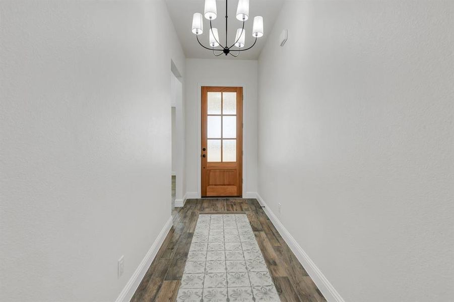 Doorway with a chandelier and wood finished floors