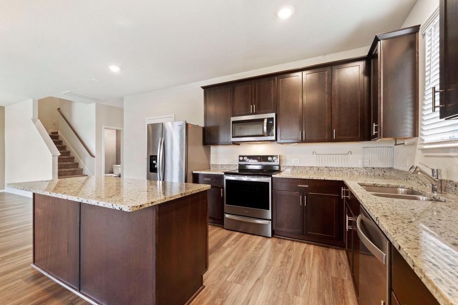 A well-appointed kitchen features rich cabinetry, lustrous granite counters, and integrated stainless steel appliances. A well-appointed kitchen features rich cabinetry, lustrous granite counters, and integrated stainless steel appliances.
