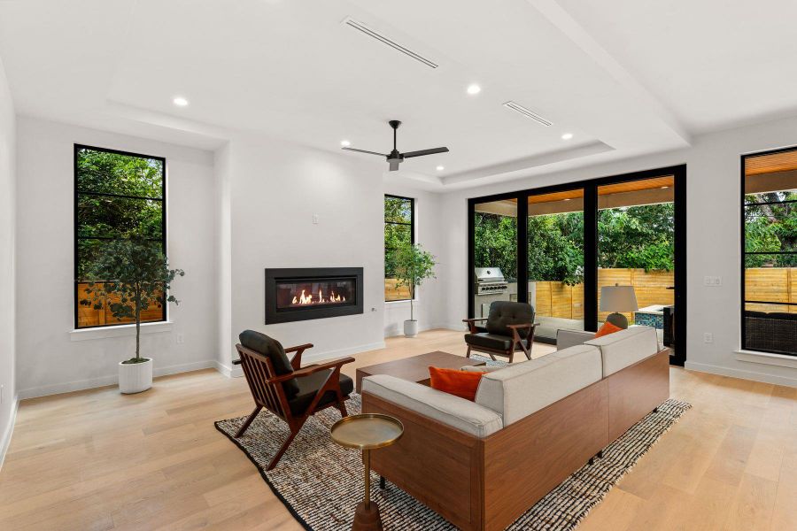 Rich hardwood flooring complements a sleek modern fireplace and sliding glass doors.