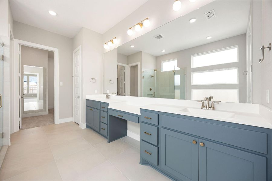 The primary bath features a dual-sink vanity with abundant cabinet storage, a private vanity desk area, and a separate walk-in shower. The primary bath features a dual-sink vanity with abundant cabinet storage, a private vanity desk area, and a separate walk-in shower.