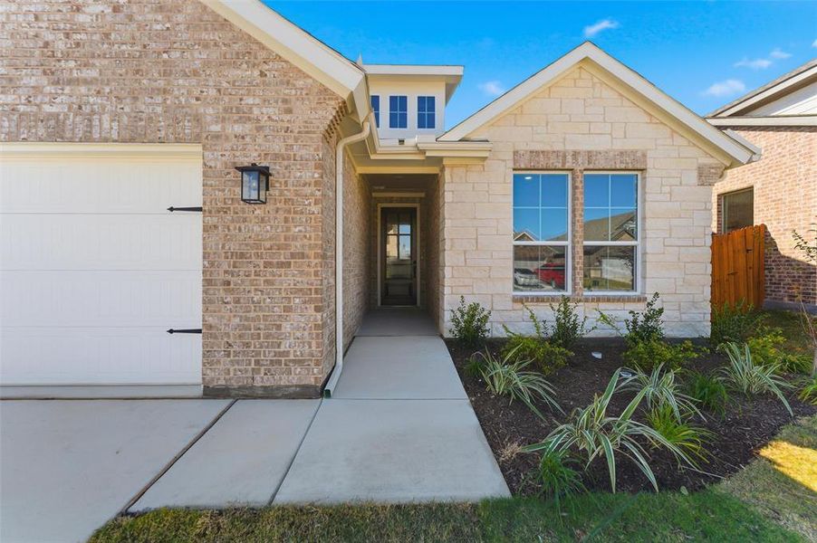 View of exterior entry featuring an attached garage