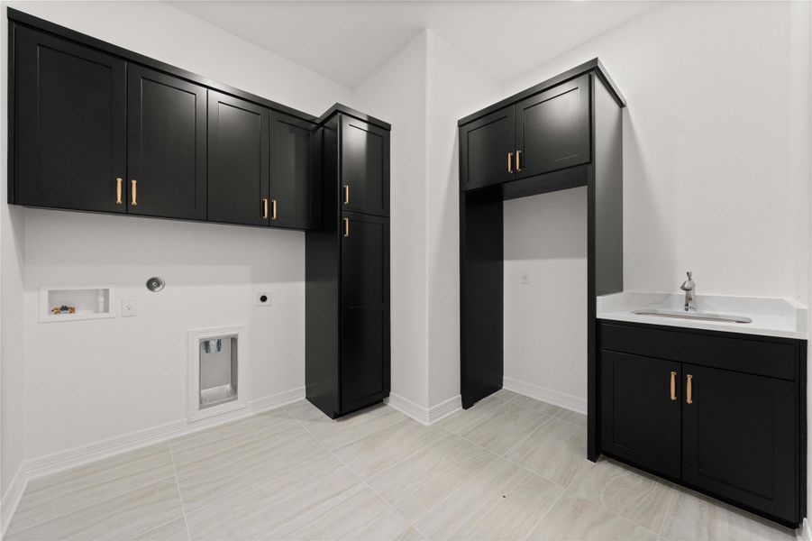 Ample storage solutions and a convenient utility sink enhance this modern laundry area. Ample storage solutions and a convenient utility sink enhance this modern laundry area.