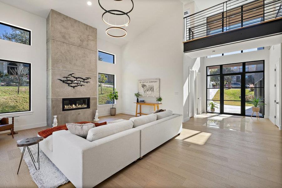 The great room offers instant wow factor with two-story vaulted ceilings and a designer statement chandelier above.