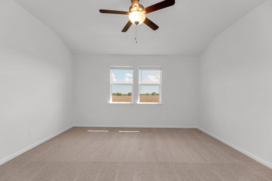 Spare room featuring light colored carpet, ceiling fan, and vaulted ceiling Spare room featuring light colored carpet, ceiling fan, and vaulted ceiling