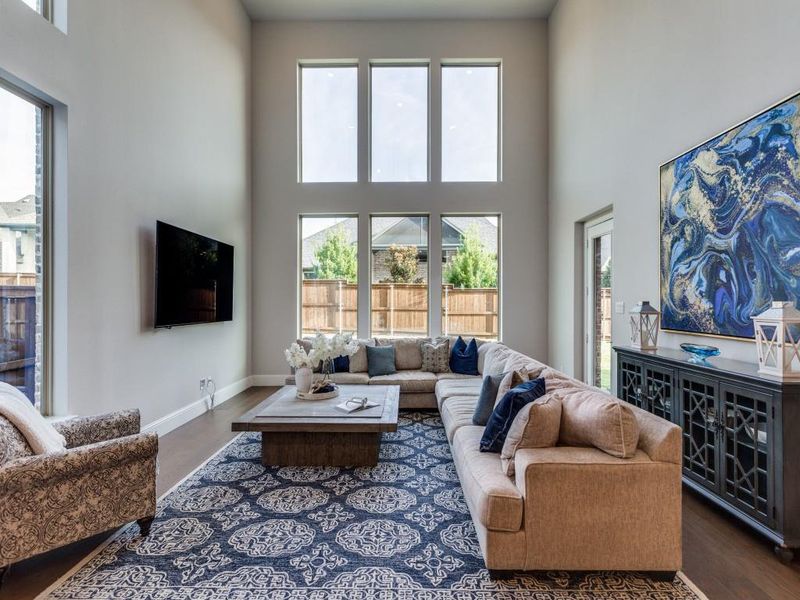 Living area with a high ceiling, plenty of natural light, and dark wood-type flooring