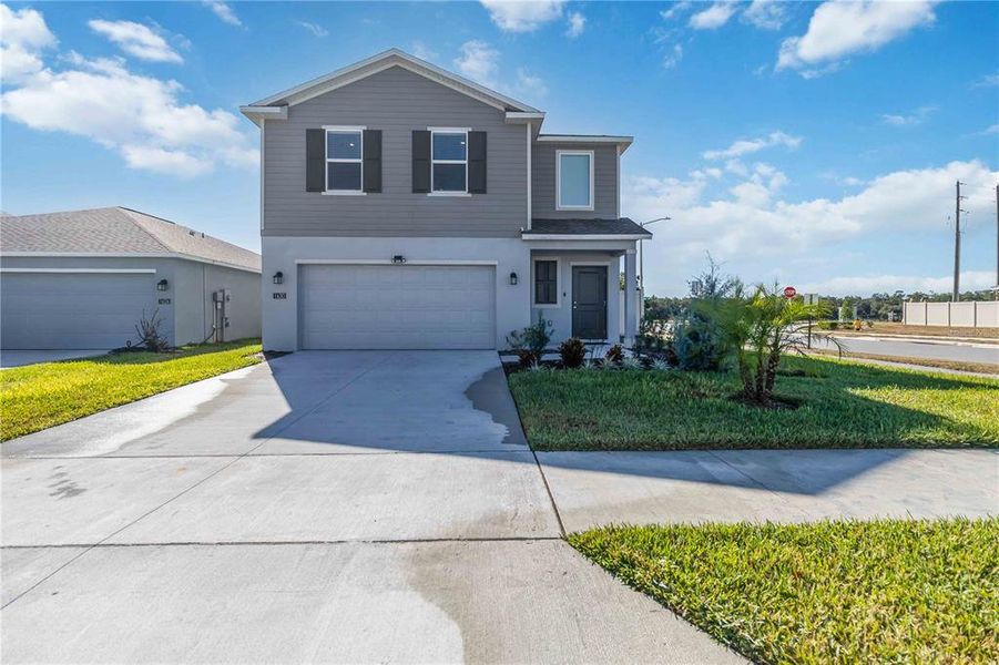 Front exterior of a new home in Peace Creek Reserve: Manor Key Collection, Winter Haven, FL, highlighting curb appeal (Image 28).