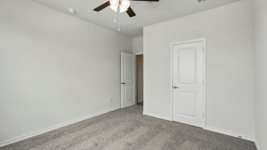 Unfurnished bedroom with carpet and a ceiling fan