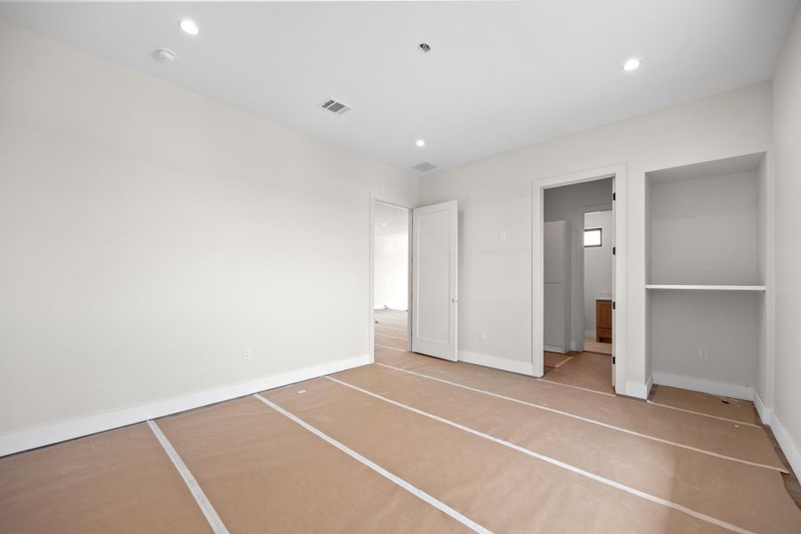 Spacious room with recessed lighting and neutral wall finishes