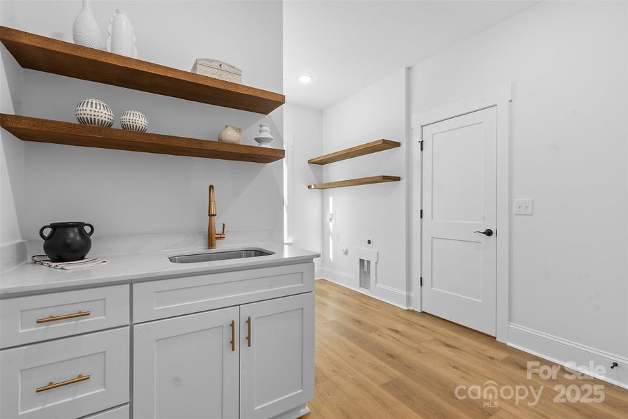 *representative photo- laundry room/mud room w/ extra storage, laundry sink, and wood shelving