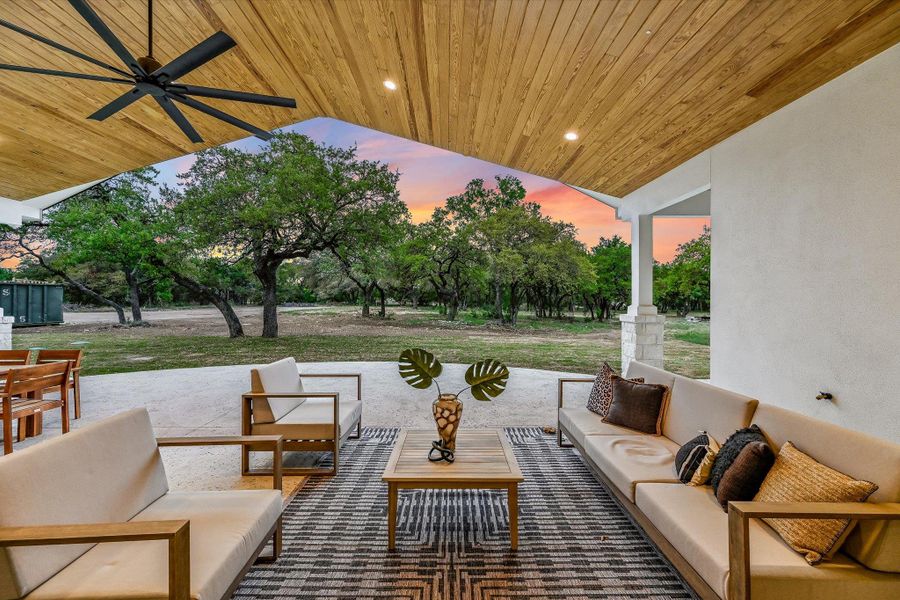 Patio terrace at dusk featuring a patio area, an outdoor living space, and a ceiling fan