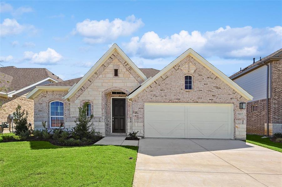 View of front of property with a garage and a front lawn