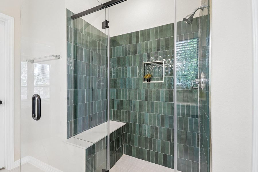 A striking tiled shower with an integrated bench offers a refreshing start to your day.