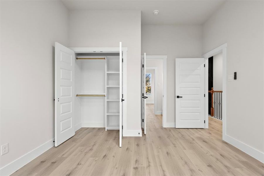 Unfurnished bedroom with light hardwood / wood-style floors and a closet