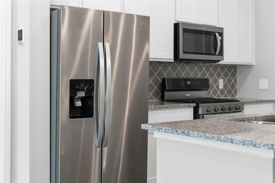 Kitchen comes equipped with a side-by-side Whirlpool refrigerator. Kitchen comes equipped with a side-by-side Whirlpool refrigerator.