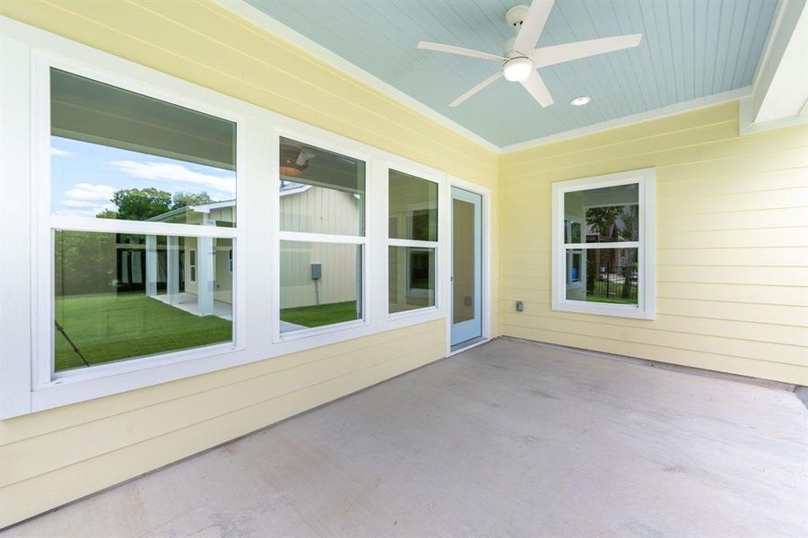 Covered patio featuring a light blue ceiling, white ceiling fan, recessed lighting, and a concrete surface Covered patio featuring a light blue ceiling, white ceiling fan, recessed lighting, and a concrete surface