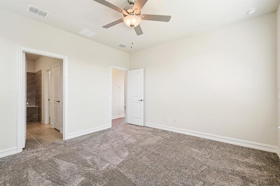 Unfurnished bedroom featuring light colored carpet and ceiling fan