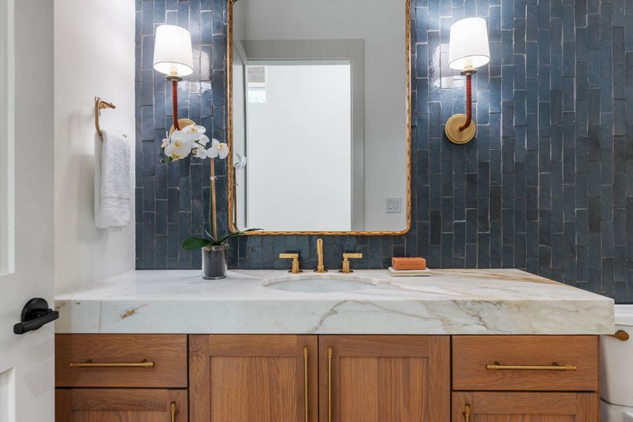 Bathroom featuring vanity and backsplash Bathroom featuring vanity and backsplash