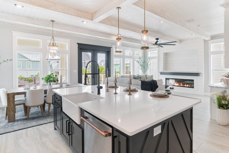Kitchen with dishwasher, open floor plan, a ceiling fan, light countertops, and a wood ceiling with exposed beams Kitchen with dishwasher, open floor plan, a ceiling fan, light countertops, and a wood ceiling with exposed beams