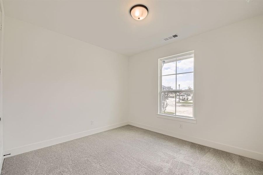 Empty room featuring light colored carpet, healthy amount of natural light, and baseboards Empty room featuring light colored carpet, healthy amount of natural light, and baseboards