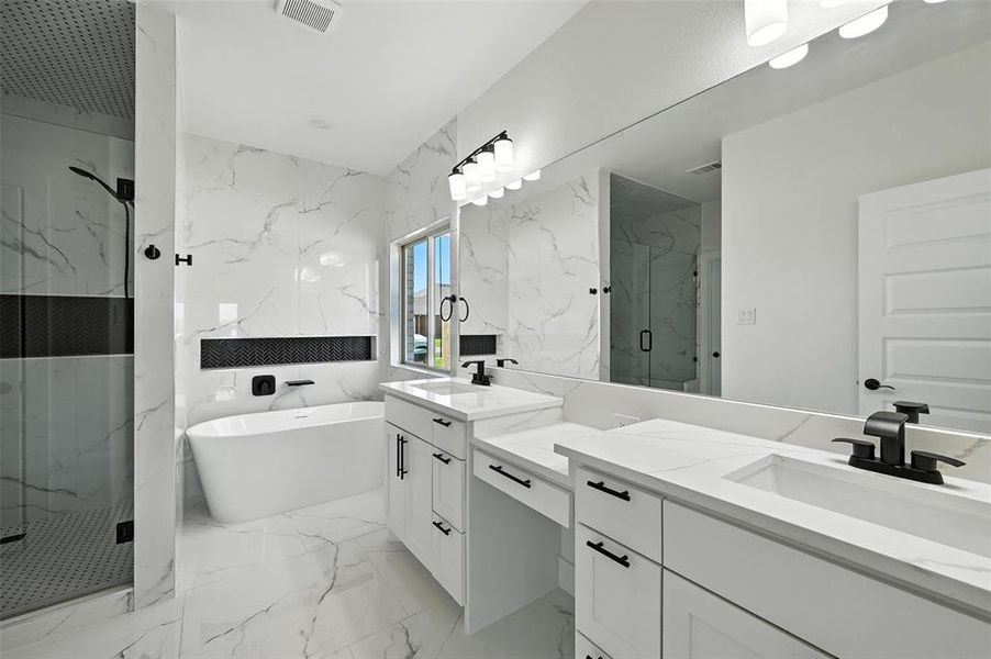 Bathroom featuring stone wall, marble tiled flooring, a marble finish shower, and double vanity