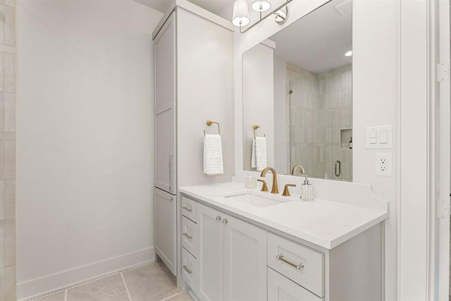 Bathroom featuring vanity, light tile patterned floors, and a stall shower