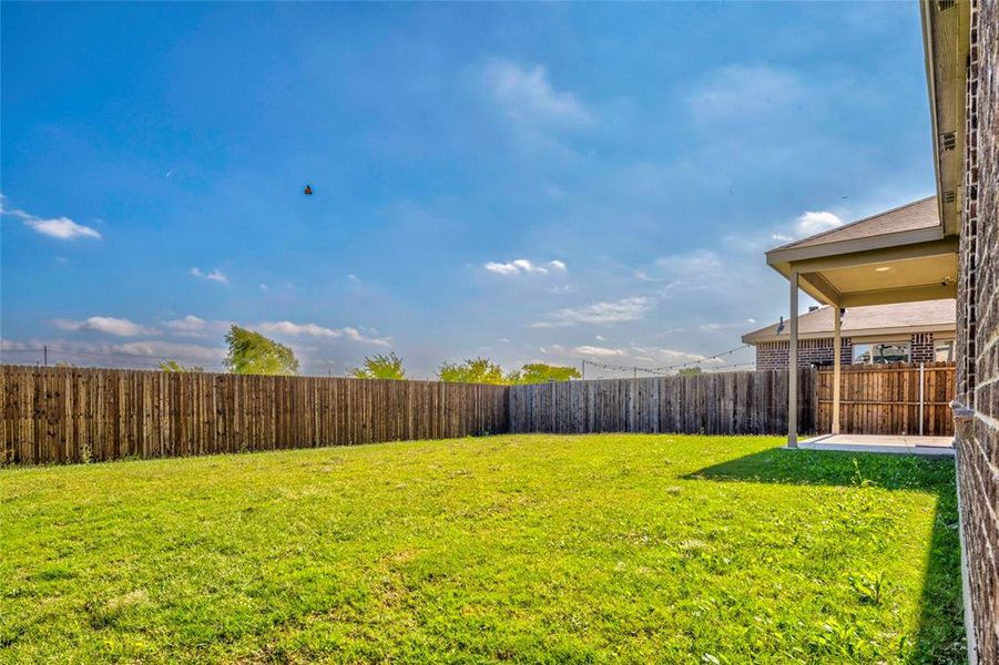 Fenced backyard with a patio area Fenced backyard with a patio area