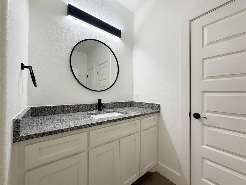 Bathroom with vanity and a textured wall