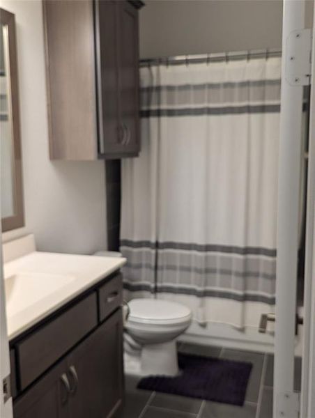 Guess Full bathroom with toilet, vanity, tile patterned flooring, and shower / bath combo