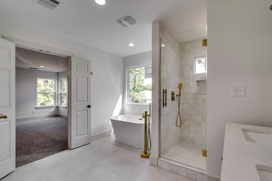 Bathroom with a wealth of natural light, plus walk in shower, tile patterned floors, and vanity