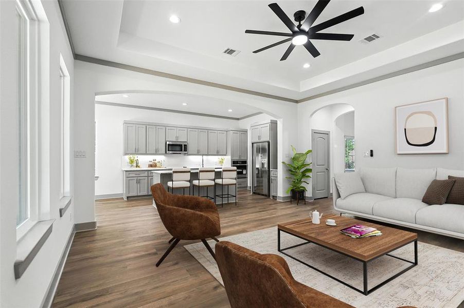 Virtually staged living area with arched walkways, a raised ceiling, dark wood finished floors, and recessed lighting Virtually staged living area with arched walkways, a raised ceiling, dark wood finished floors, and recessed lighting