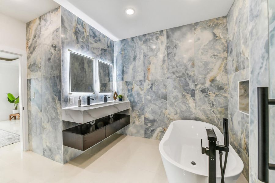 Dual sinks and generous counter space make busy mornings easier. Floating cabinetry and illuminated mirrors bring a clean, elevated finish to the primary bath. Dual sinks and generous counter space make busy mornings easier. Floating cabinetry and illuminated mirrors bring a clean, elevated finish to the primary bath.