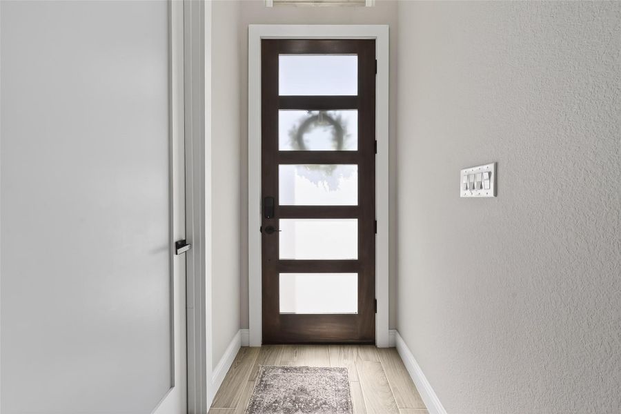 Inviting entryway with modern front door and welcoming foyer. Inviting entryway with modern front door and welcoming foyer.