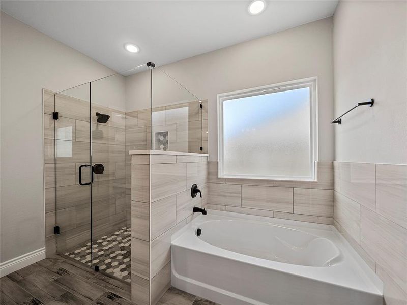 Bathroom featuring a shower stall, a bath, wood tiled floors, and recessed lighting Bathroom featuring a shower stall, a bath, wood tiled floors, and recessed lighting