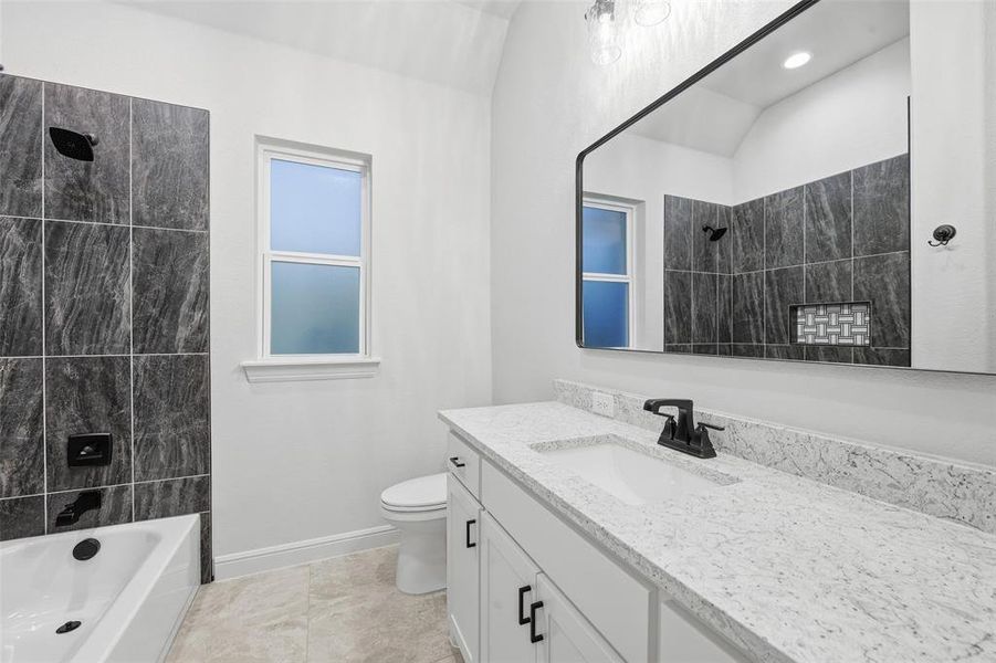 Bathroom with vanity, tub / shower combination, and light tile patterned floors Bathroom with vanity, tub / shower combination, and light tile patterned floors