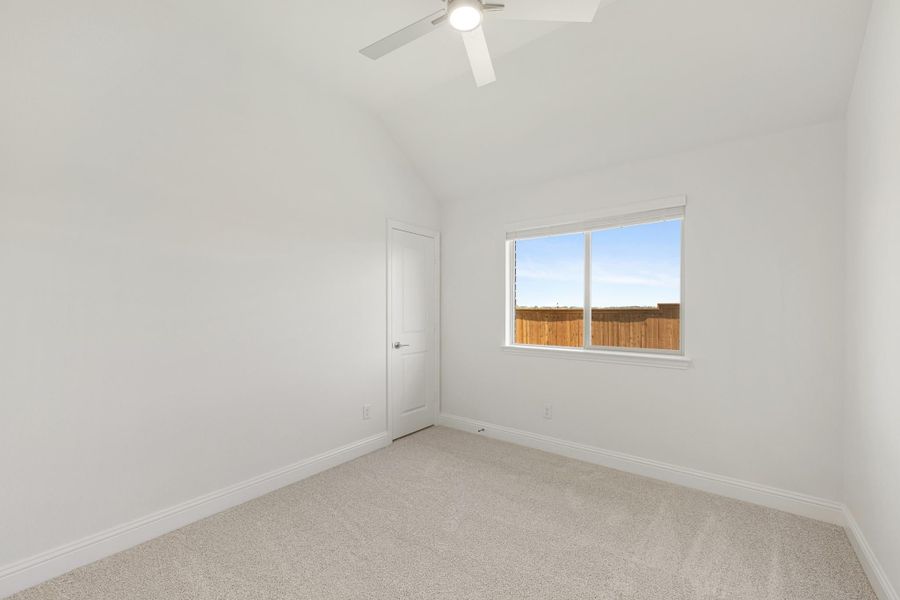 Empty bedroom with vaulted ceiling, ceiling fan, carpet flooring, and single window