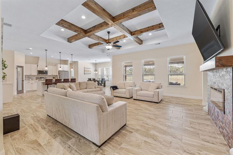 Living room with coffered ceiling, beamed ceiling, a ceiling fan, a fireplace, and recessed lighting Living room with coffered ceiling, beamed ceiling, a ceiling fan, a fireplace, and recessed lighting