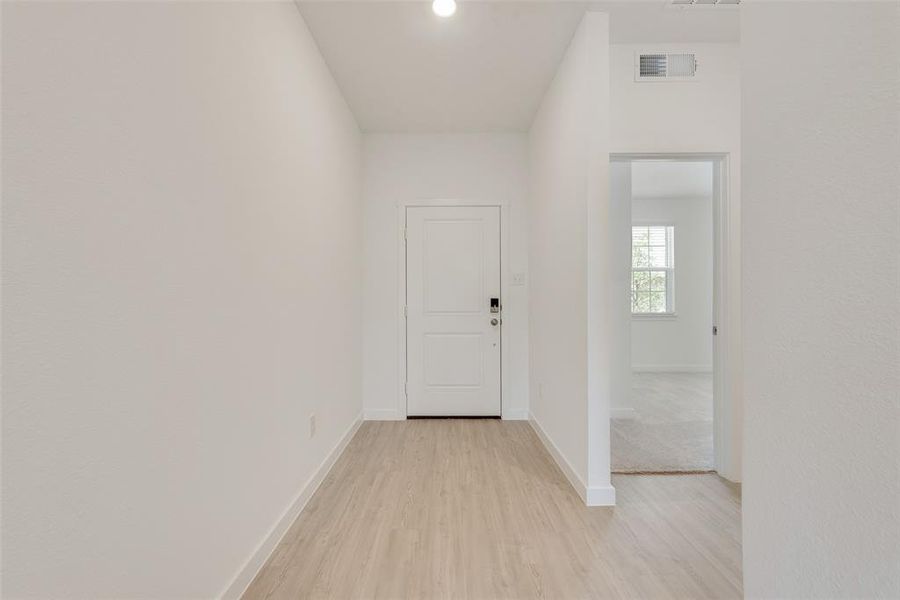 Hall with light hardwood / wood-style floors