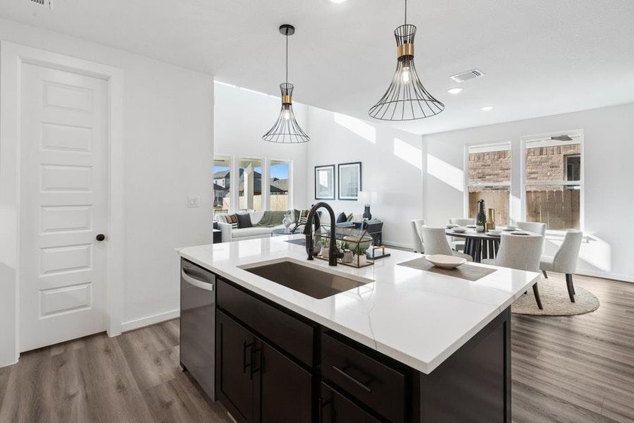 Kitchen with open floor plan, dark wood-type flooring, pendant lighting, dishwasher, and an island with sink Kitchen with open floor plan, dark wood-type flooring, pendant lighting, dishwasher, and an island with sink
