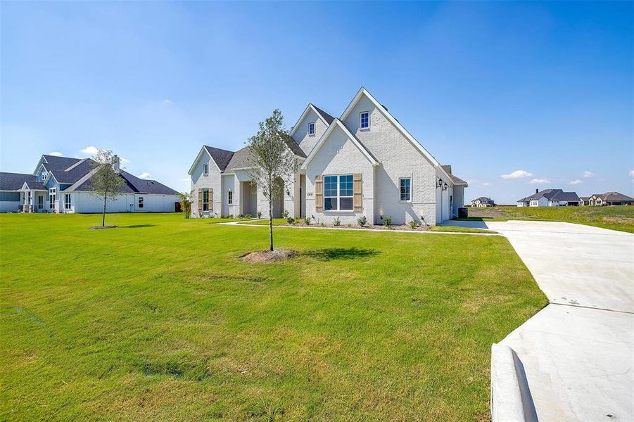 View of front facade with a garage and a front lawn