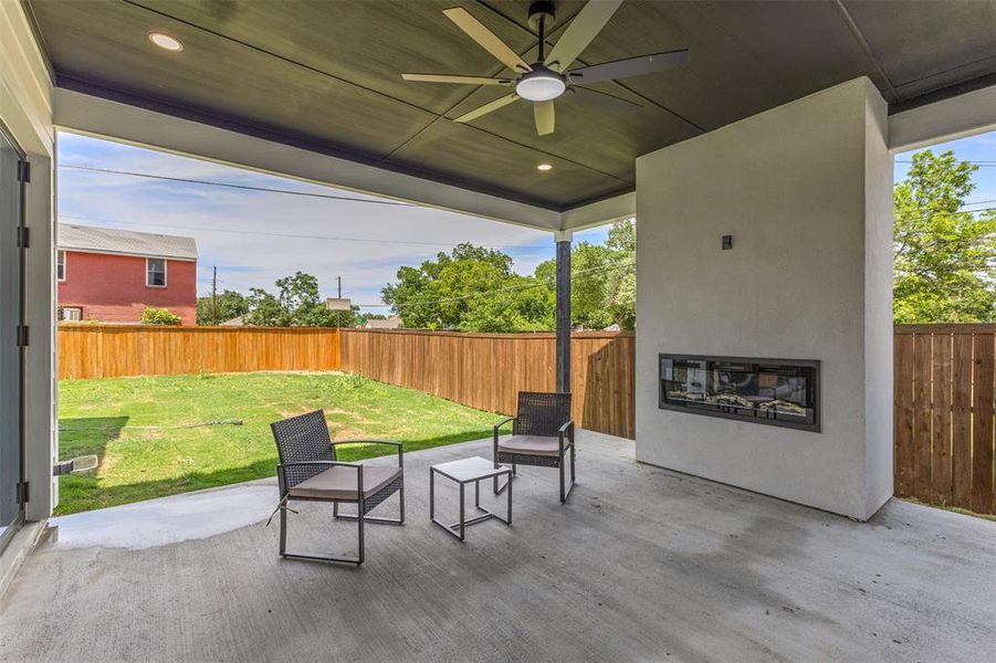 Covered patio featuring a built-in fireplace, ceiling fan, recessed lighting, and concrete flooring