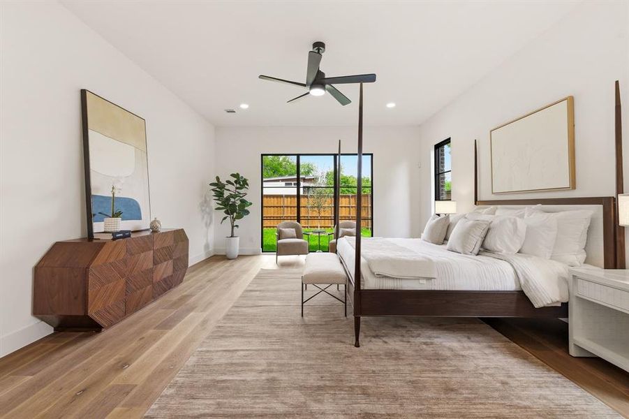 Spacious bedroom featuring light wood-finish flooring, recessed lighting, and a modern ceiling fan