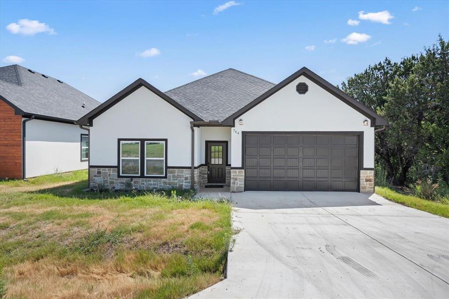 View of front of house featuring a garage and a front yard