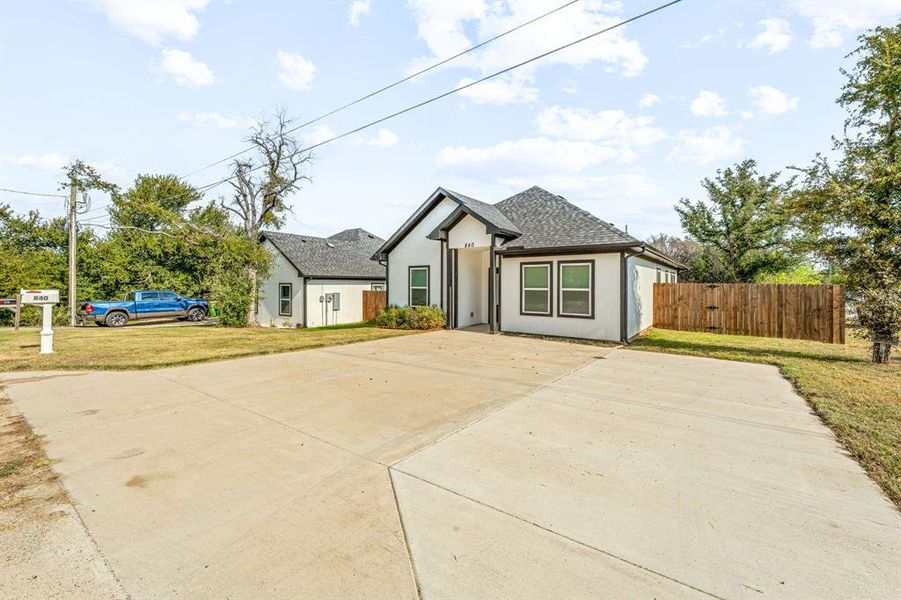 View of front facade featuring stucco siding, a shingled roof, and driveway View of front facade featuring stucco siding, a shingled roof, and driveway