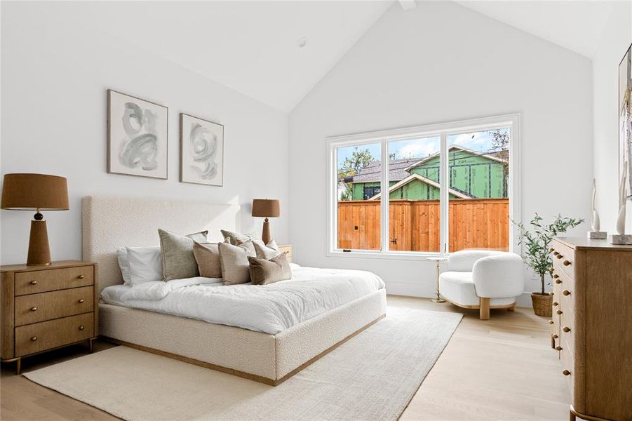 Bedroom featuring light wood finished floors and high vaulted ceiling